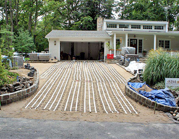 Installing the heating mats over paver dust.
